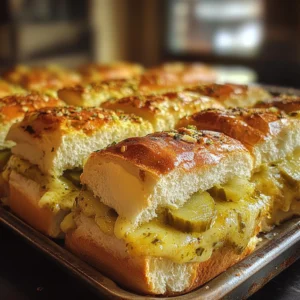 A tray of golden-brown Pickle-Garlic Butter Cuban Inspired Pull-Apart Sliders, filled with ham, Swiss cheese, and tangy pickles, topped with a flavorful garlic butter glaze.