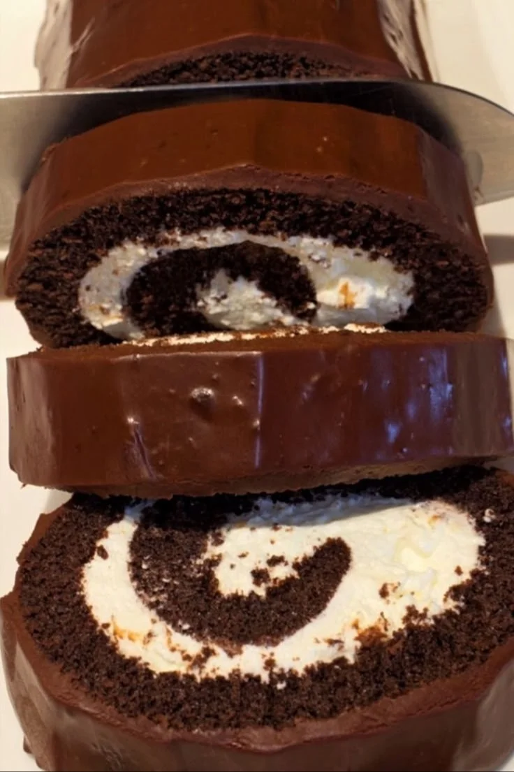 Delicious chocolate cake roll dessert on a plate garnished with chocolate shavings