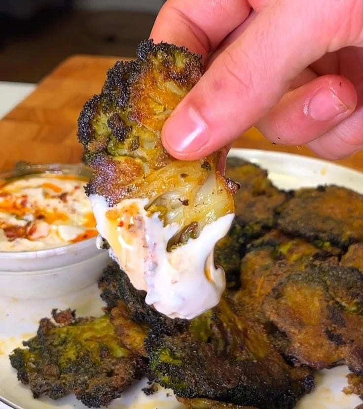 Crispy smashed broccoli chips served in a white bowl on a wooden table