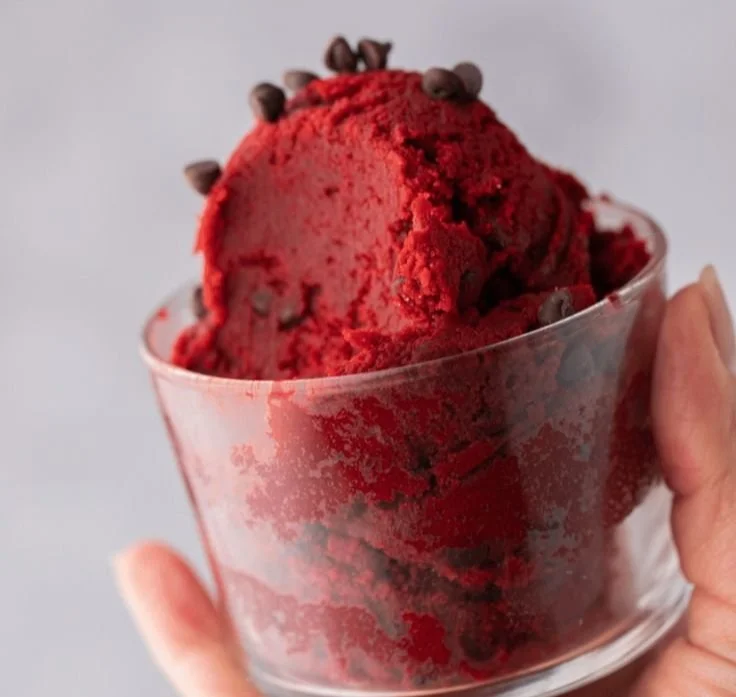 Homemade red velvet edible cookie dough in a bowl with sprinkles.