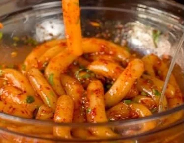 Plate of spicy potato noodles garnished with herbs and spices