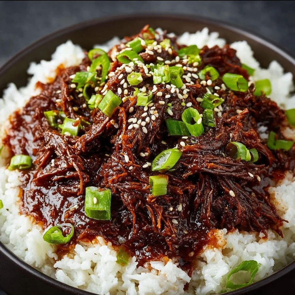Delicious Slow Cooker Korean Beef served with rice and garnished with green onions.
