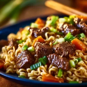 Slow Cooker Beef Ramen Noodles in a bowl, topped with fresh herbs and vegetables.