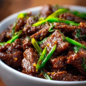 Slow Cooker Mongolian Beef served in a bowl with rice and vegetables